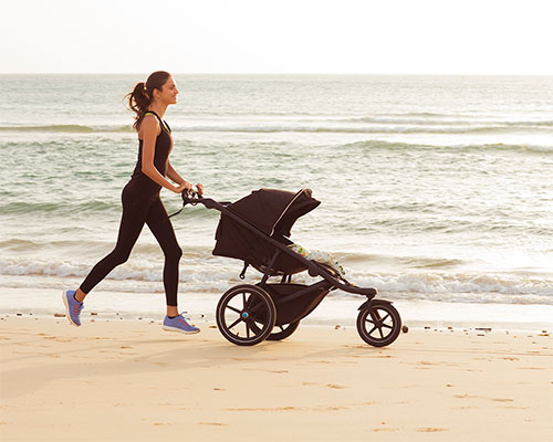Mom running on the beach with stroller